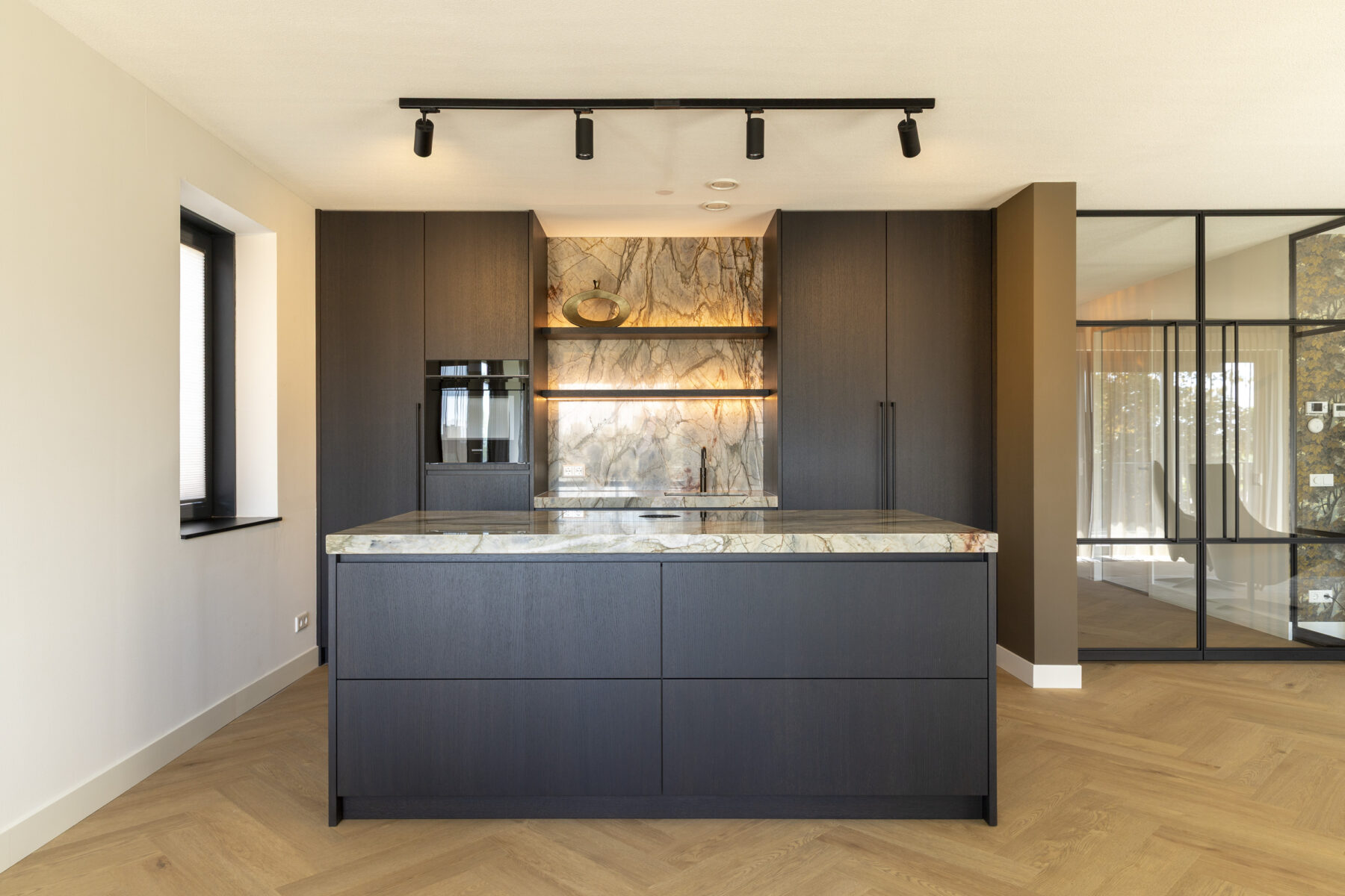 Keuken in warme moderne stijl met donker hout, nis en symmetrische wandopstelling.