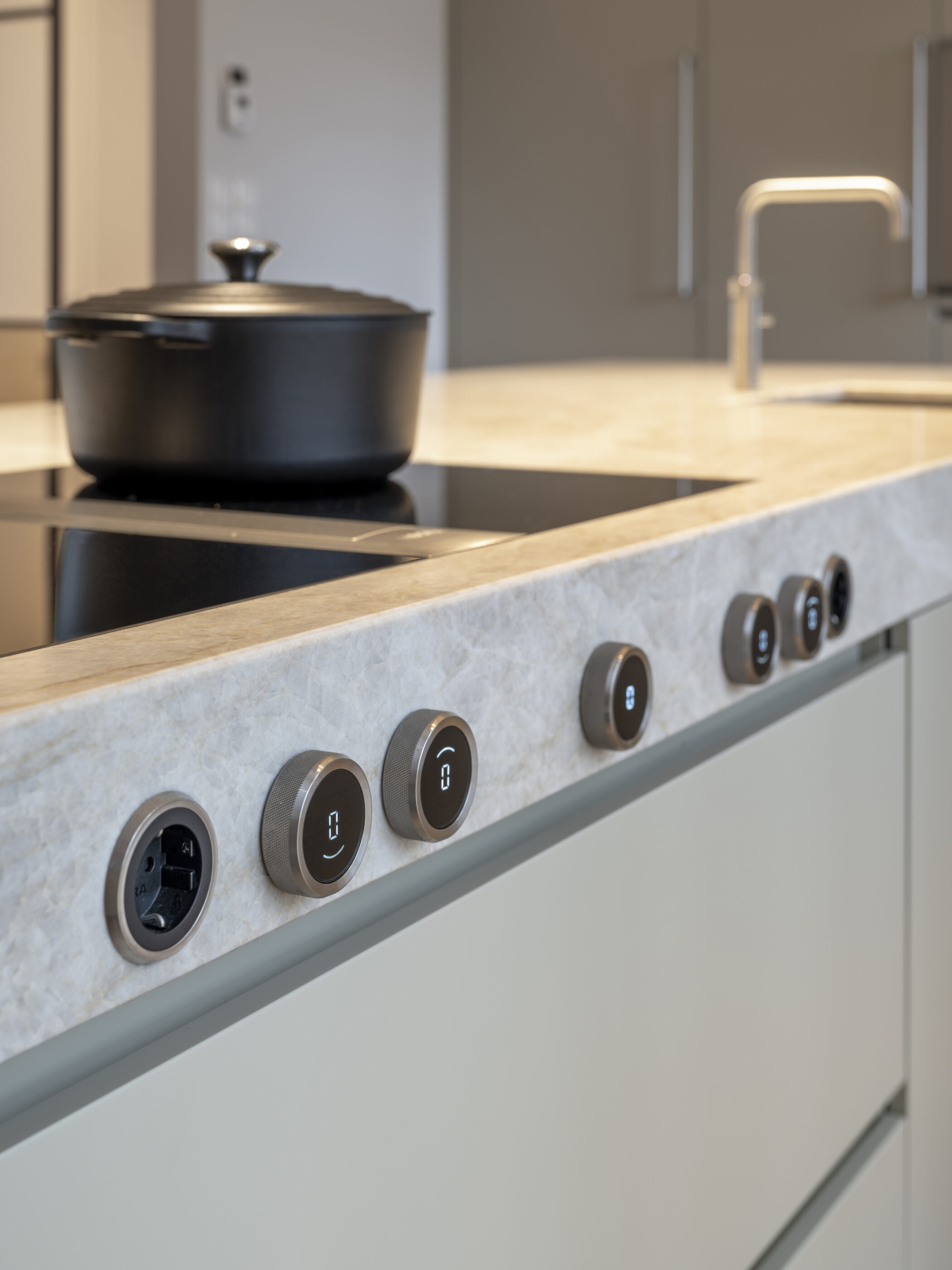 Moderne grijze keuken met kookeiland en luxe designapparatuur, waarin functionaliteit en esthetiek samenkomen.